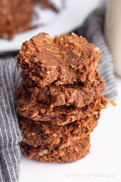 chocolate cookies stacked on top of each other with a glass of milk in the background