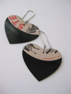 pair of black and white heart shaped earrings with sale sticker on it's side