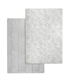 two sheets with white leaves on them, one is folded up and the other has a gray