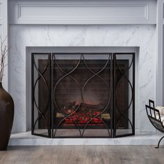 a fireplace with a fire in it next to a chair and vase on the floor