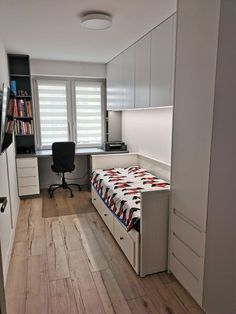 a room with a bed, desk and bookcases on the wall in it