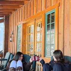 two women sitting on the porch drinking coffee