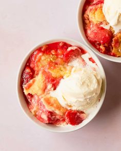 two bowls filled with ice cream and strawberries on top of a white table next to each other