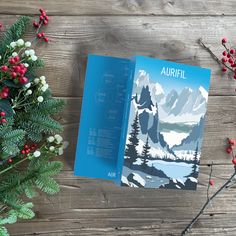 an open book sitting on top of a wooden table next to flowers and branches with red berries