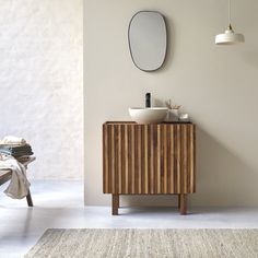 a bathroom with a sink, mirror and rug on the floor in front of it