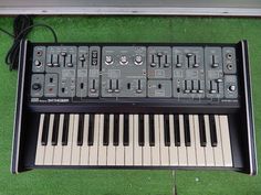 an electronic keyboard sitting on top of green grass