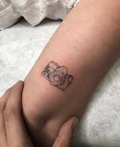 a person with a camera tattoo on their arm