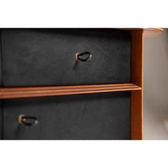 two black drawers with brass handles on each side and one drawer closed to the other