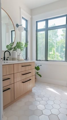 a bathroom with large windows and white tiles on the floor is pictured in this image