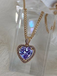 The Mini Lavender Heart Necklace is so dreamy! This bombshell features a light lavender heart-shaped cubic zirconia stone embraced in a micro pave encrusted frame suspended from a dainty chain! Get your hands on this centerfold or one of her glitzy besties below: - The Mini Ruby Heart Necklace - The Mini Crystal Heart Necklace - The Mini Pink Heart Necklace Available in 24K gold or rhodium plating over steel Patent plating & sealant technology to ensure durability and long lasting wear Made Heart Gem Necklace, Glamorous Heart-shaped Cubic Zirconia Jewelry, Purple Double Heart Jewelry For Valentine's Day, Valentine's Day Purple Diamond Jewelry, Purple Double Heart Charm Jewelry, Purple Double Heart Jewelry With Heart Charm, Purple Cubic Zirconia Jewelry For Valentine's Day, Purple Heart Cut Cubic Zirconia Jewelry, Elegant Purple Heart Cut Necklace