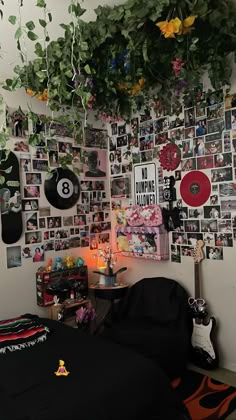 a bedroom with lots of pictures on the wall and plants hanging from the ceiling over the bed