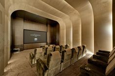 an empty theater with chairs and a projector screen in the middle of the room