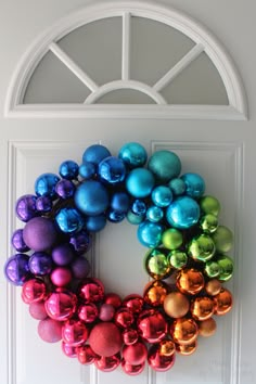 a colorful christmas ornament hanging on a white door with an arched glass window