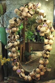 a mirror that has some baskets on it and plants in the reflection behind it,