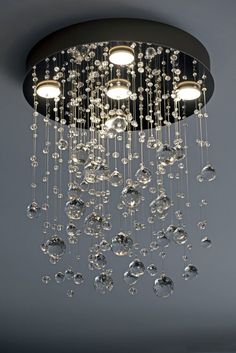 a chandelier hanging from the ceiling in a room with grey walls and flooring