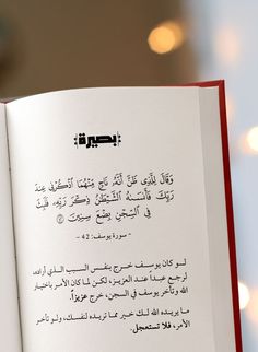 an open book with arabic writing on the page and lights in the backround