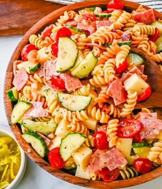 a wooden bowl filled with pasta salad and dressing