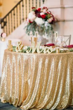 the table is covered with gold sequins and mr and mrs signs on it