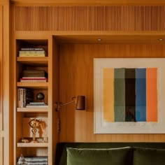 a living room with wood paneling and bookshelves on either side of the couch