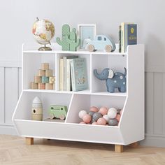 a white book shelf with books and toys on it in a child's room