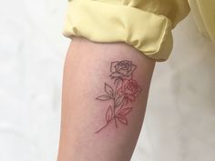 a woman's leg with a rose tattoo on the left side of her thigh