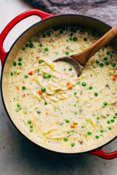 a red pot filled with soup and peas