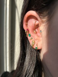 a close up of a person's ear with some piercings on it,