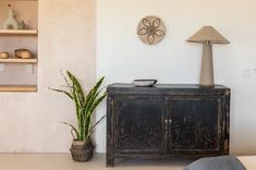 a black cabinet sitting next to a lamp on top of a table