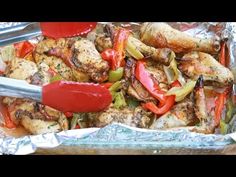 chicken and peppers in foil with tongs on the side, ready to be cooked