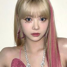 a woman with long blonde hair wearing pink and silver necklaces, earrings and bracelets