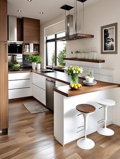 a modern kitchen with white cabinets and wood flooring is pictured in this image, there are two stools at the center of the island