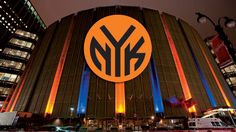 an orange and blue building with the word ny on it's side at night