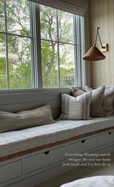 a window seat with some pillows on it