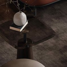 a white vase sitting on top of a wooden table next to a red bath tub