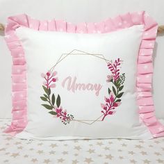 a white pillow with pink ruffle trim and an embroidered name on the front that says mommy