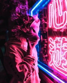 a person standing in front of a neon sign