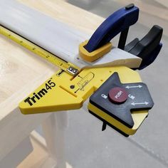 a yellow and black measuring tool on top of a wooden table