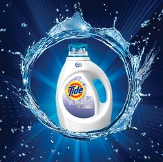 a bottle of tide ultra with water splashing around it on a dark blue background