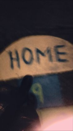 a skateboard with the word home written on it's back end in front of a blurry background