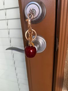 an apple keychain hanging from a door handle