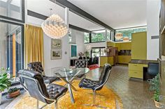 a dining room table with chairs and a chandelier hanging from it's ceiling