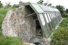 a building made out of rocks with a green roof