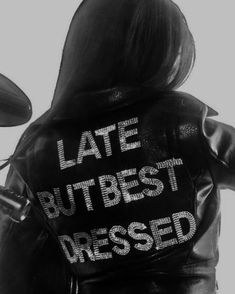 the back of a woman's leather jacket that says, late but best dressed