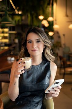 a woman sitting in a chair holding a cup of coffee