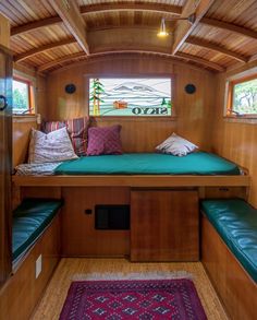 the inside of a small cabin with green cushions