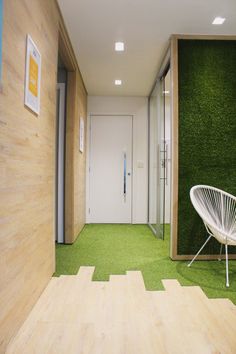 a white chair sitting on top of a green carpeted floor next to a doorway