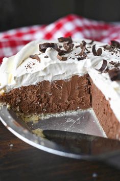 a piece of chocolate pie with whipped cream and chocolate chips on top, sitting on a plate