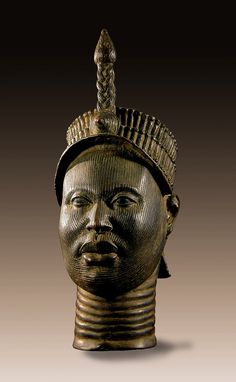 an old bronze head with a hat on it's head and braids in its hair