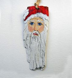 an ornament with a santa clause on it hanging from a rope in front of a white wall