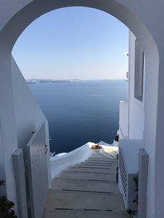 an arched doorway leading to the ocean with steps going up and down it's sides